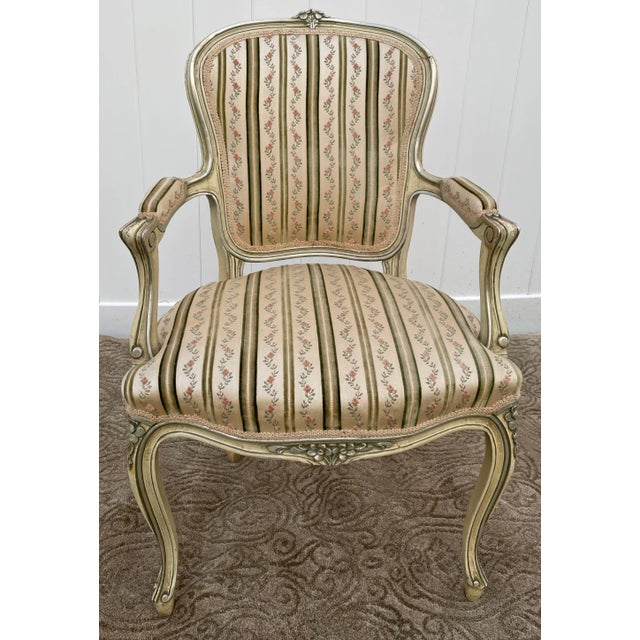 This Vintage Arm Chair has a Venetian Style . The Frame is Wood. The Color is Cream with a Distressed Finish. Stripe...