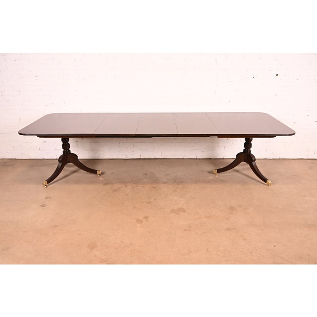 An exceptional Georgian or Regency style double pedestal extension dining table By Baker Furniture USA, Circa 1980s...
