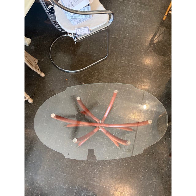 Iconic Italian Modern coffee table in the style of Paolo Buffa, featuring a sculptural walnut spider base with brass...