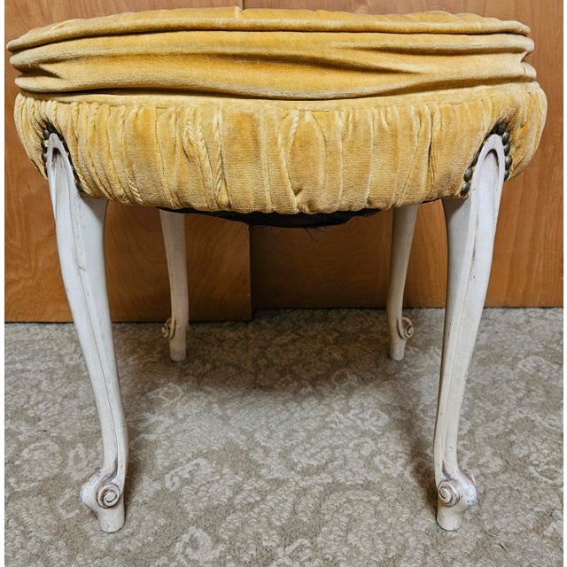 This vintage upholstered vanity stool features a classic French-inspired silhouette with elegant cabriole legs and a...