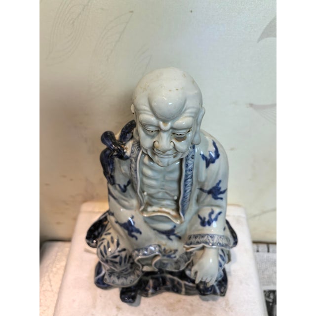 W-19cm,H-31cm This hand-carved blue and white porcelain statue depicts The Eighteen Arhats, a traditional Chinese Buddhist...