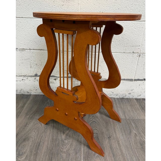 This is a signed studio-crafted Arts & Crafts style round side table with a sculptural lyre or harp form base, spindle...