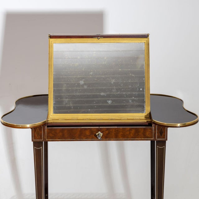 Transformation table, on high square pointed legs with brass sabots and curved table top including intermediate shelf with...
