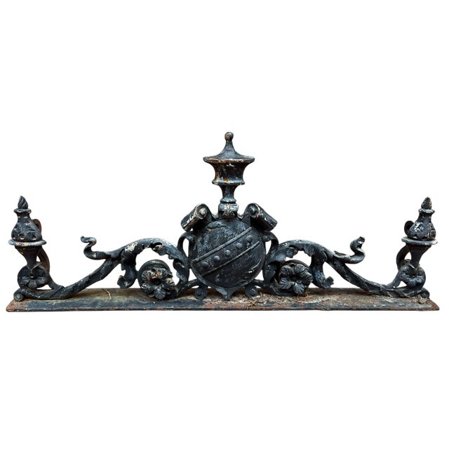 A magnificent pair of antique cast iron architectural remnants, each featuring a central heraldic shield flanked by...