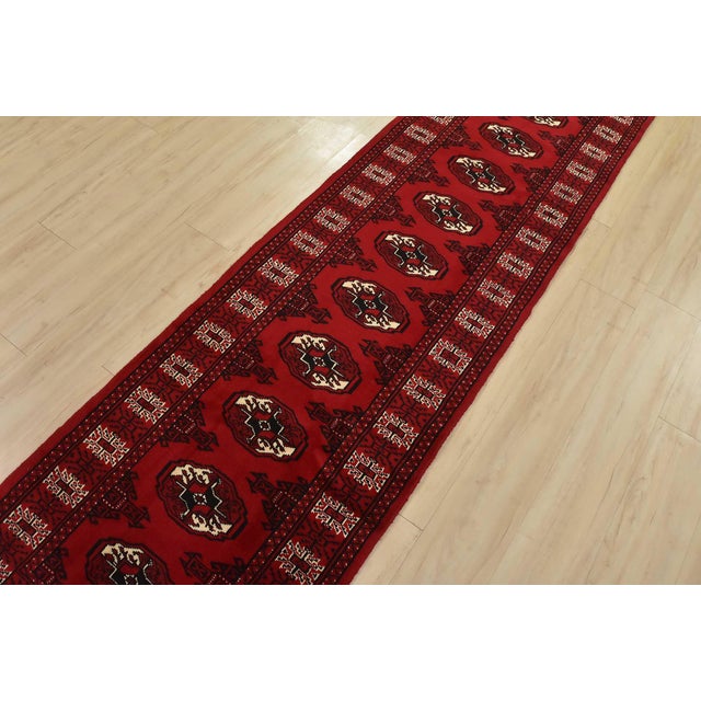 An authentic vintage tribal Turkmen runner, hand-knotted with fine wool and natural dyes. This nomadic rug features a row...