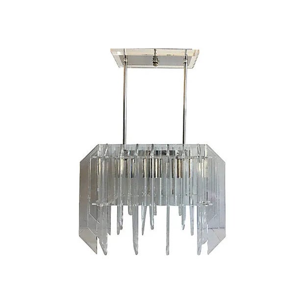 Spectacular oversize 1970s modern Lucite skyscraper ceiling chandelier featuring staggered and beveled Lucite fins in a...