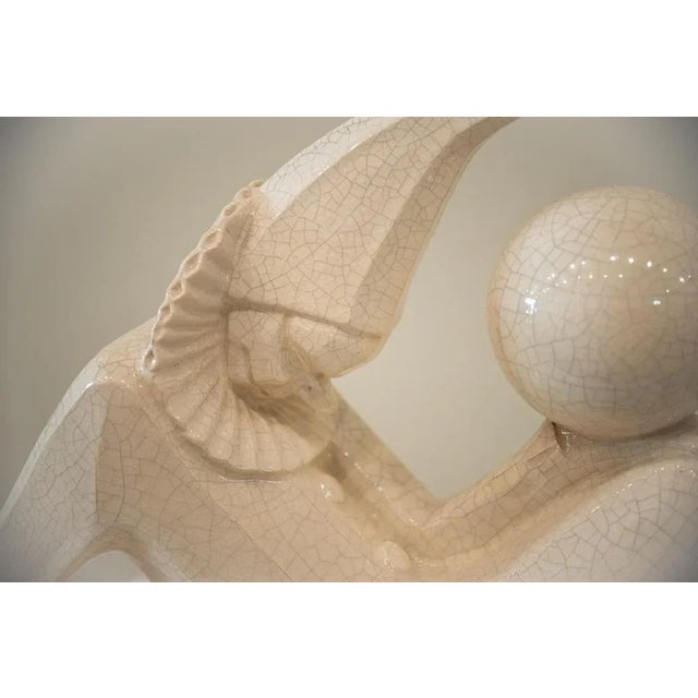 Harlequin-shaped ceramics, clown, lying down holding a ball in his left hand and leaning back on his right hand. Pasas of...