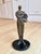 A striking limited-edition cast-bronze sculpture depicting an elongated female figure with her face dramatically lifted...