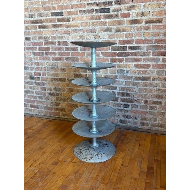 Bring raw, heavy-duty factory grit into your space with this salvaged industrial multi-tier carousel axle. This solid...