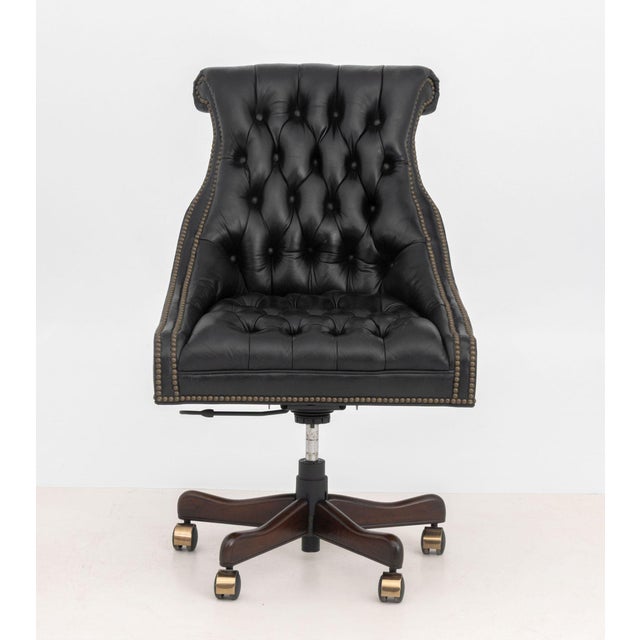 Chesterfield Black Leather Executive Chair, button-tufted upholstery with riveted details, atop a wood base above casters....