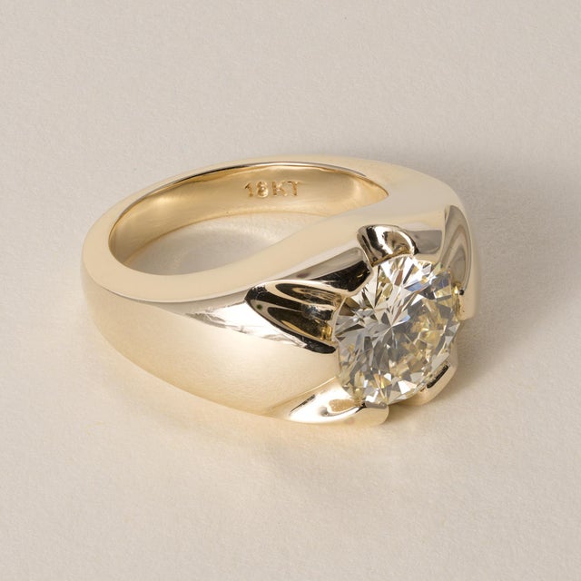 This vintage-inspired statement ring features a repurposed round brilliant cut diamond set in a richly textured 18K yellow...