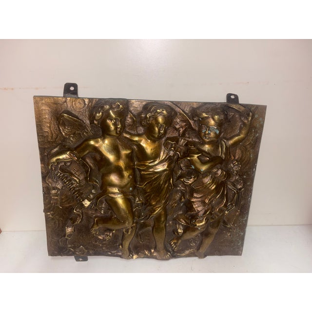Antique bronze decorative plaque depicting three dancing or musical cherubs, 29 cm wide, 5 cm deep, 28 cm high with hooks,...