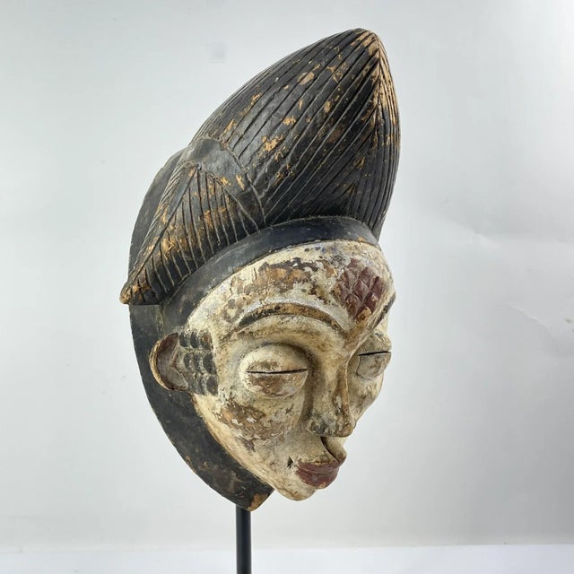 The Mmwo Spirit Maiden Mask originates from the Punu people of Gabon and is used in a variety of cultural contexts,...
