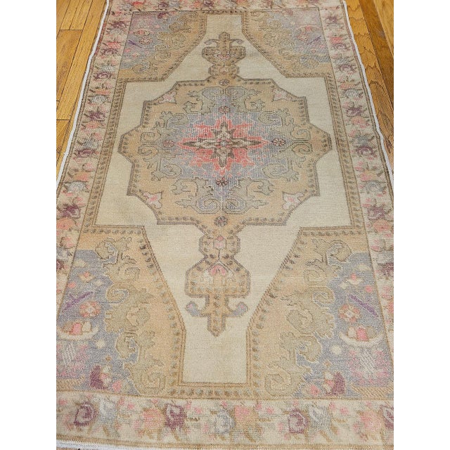This elegant Vintage Turkish Oushak area rug was hand knotted in western Anatolia in the mid-1900s, the rug features a...