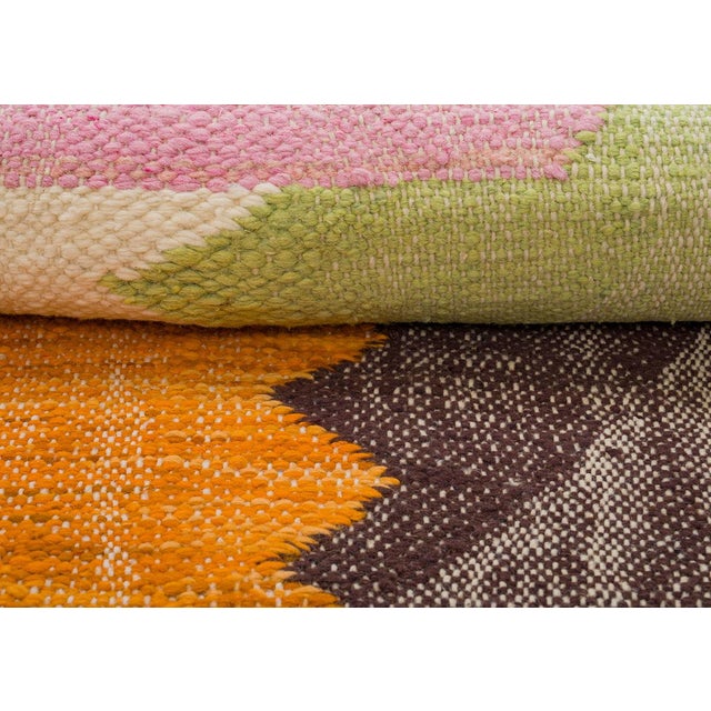 Exquisite handwoven wool rug showcasing playful blocks of Espresso Brown, Saffron Orange, Lime Green, and Blossom Pink on...