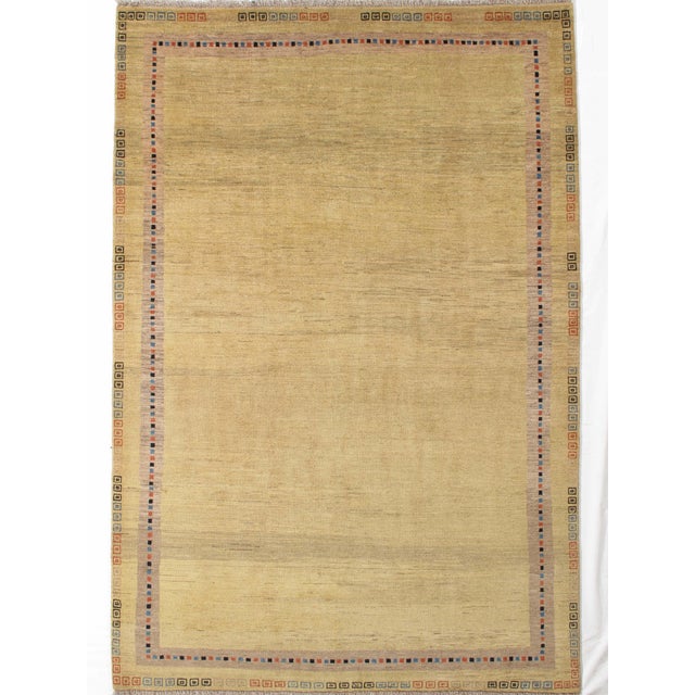 Vintage Hand-knotted Persian Lori Gabbeh rug featuring a soft golden-beige field with a subtle, minimalist aesthetic. The...