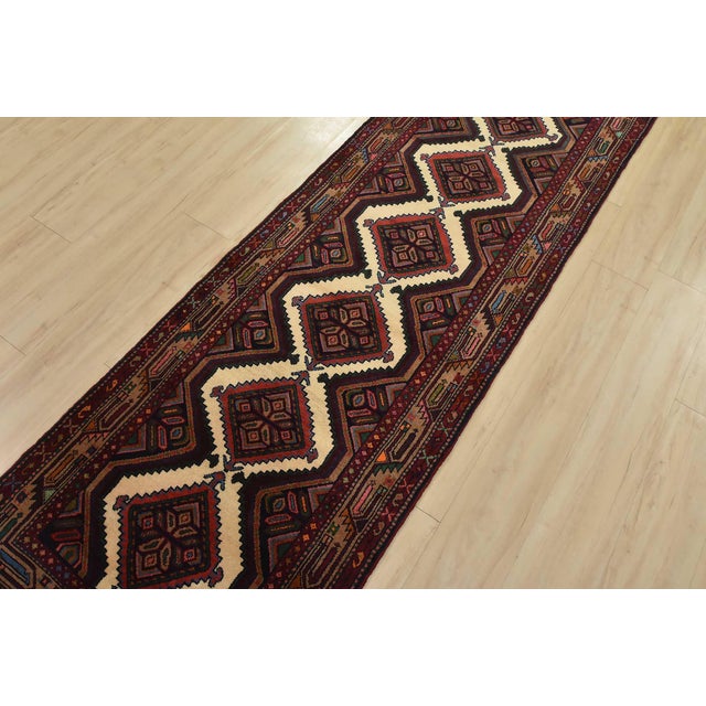 An authentic vintage tribal Hamedan runner hand-knotted with fine wool and natural dyes. This nomadic rug features a row...