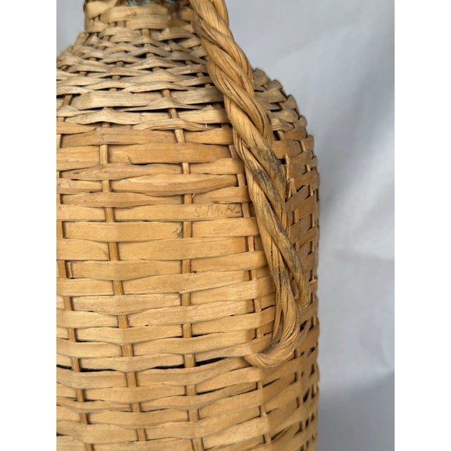 This charming vintage Bacardi bottle is a standout piece of mid-century barware, featuring an intricately handwoven wicker...