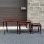 A nest of three vintage Chinese Traditional solid rosewood tables, each having a rounded framed top over a serpentine...
