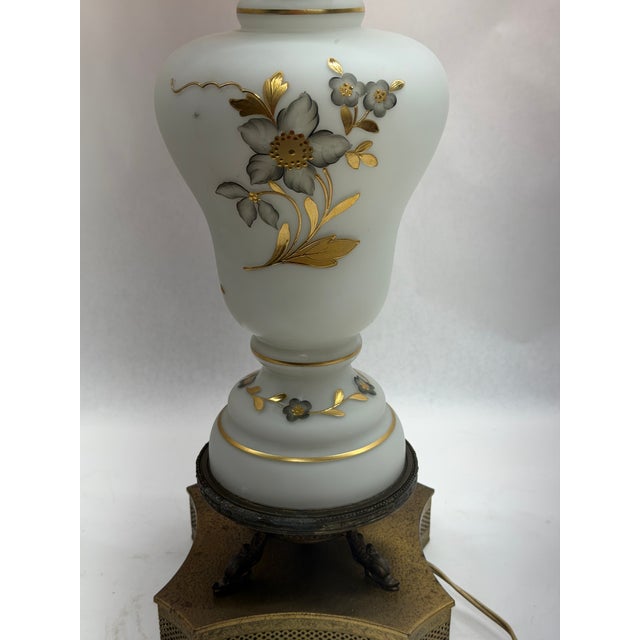 Vintage Victorian-style table lamp featuring an urn-form body of smooth satin white/Bristol glass, decorated with hand-...