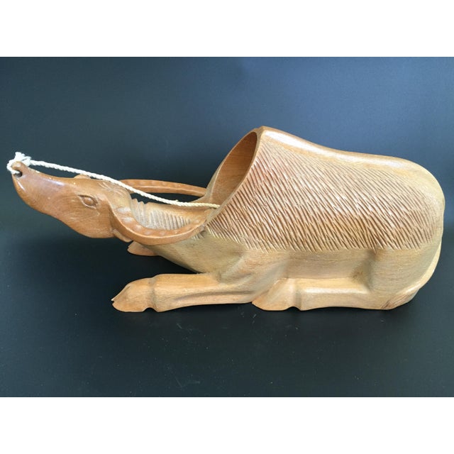 Presenting a Mid Century water buffalo figural wooden wine bottle holder. This unique handcrafted piece features a light...