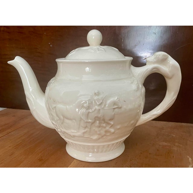 This is a classy and classic off white color teapot from Wedgewood's Devonshire line with two different embossed hunting...