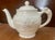 This is a classy and classic off white color teapot from Wedgewood's Devonshire line with two different embossed hunting...