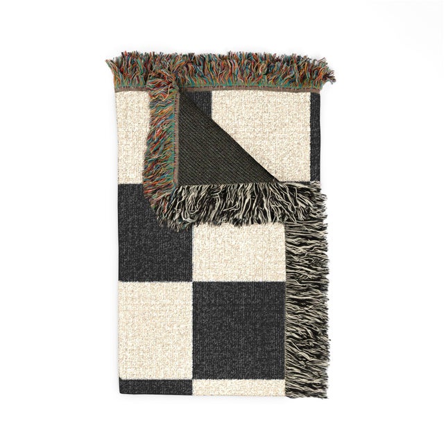 This black and cream checkerboard woven throw blanket features oversized checks and decorative fringe. This lightweight,...