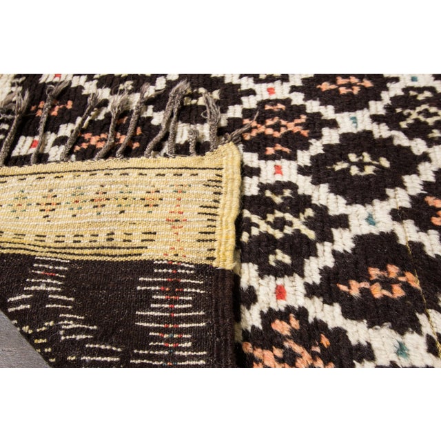 This beautiful vintage Moroccan hand-knotted wool rug features a tribal design that will enhance the look of your floor....