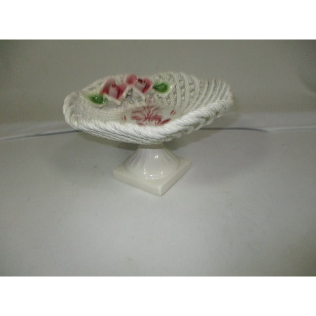 A handcrafted white ceramic pedestal bowl. This twisted woven rope basket design bowl has hand painted applied pink roses...