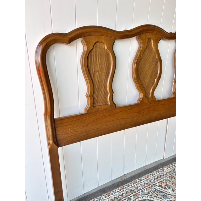 Crafted from solid wood with a warm medium-tone finish, the headboard showcases elegant carved lines and five cane-backed...