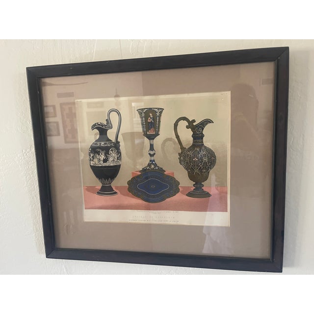 This framed chromolithograph of decorative porcelain pieces was produced in the 1860 period. It showcases classical-style...