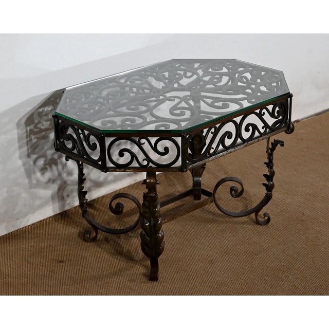 This coffee table, rectangular with sides cut in the corners, is decorated with a belt -wrapped scroll belt, and covered...