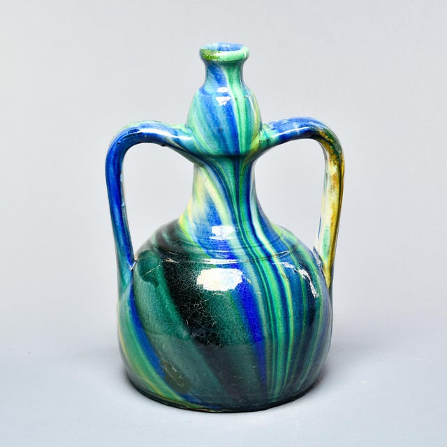 A vibrant and expressive Vallauris pottery ewer featuring the region's signature flowing multicolor glaze in cobalt blue,...
