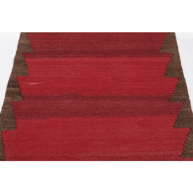 Made with handwoven wool circa 1950-1960, this 3x8 vintage Bidjar Kilim is a particularly bright and sought-after work of...