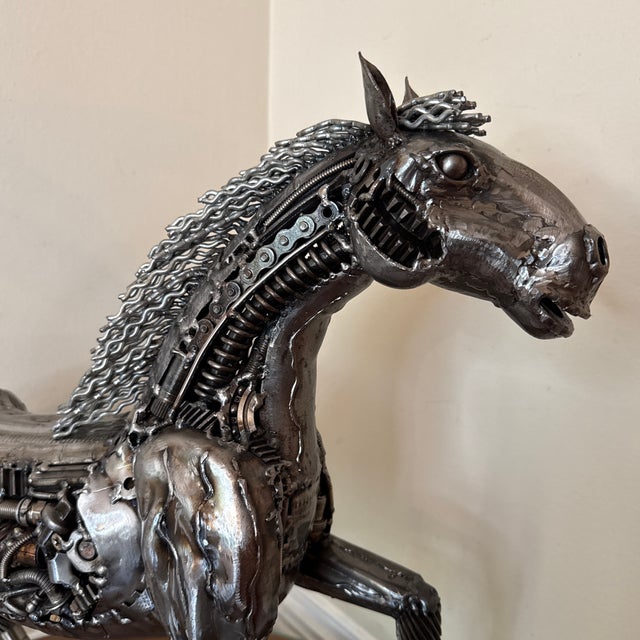 Elevate your space with this striking steampunk-style horse sculpture crafted entirely from recycled mechanical parts....