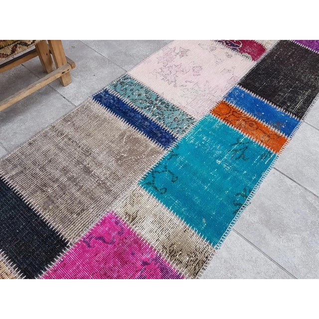 This is a vintage Turkish Oushak rug from the Mid 20th Century. The piece was hand-knotted.