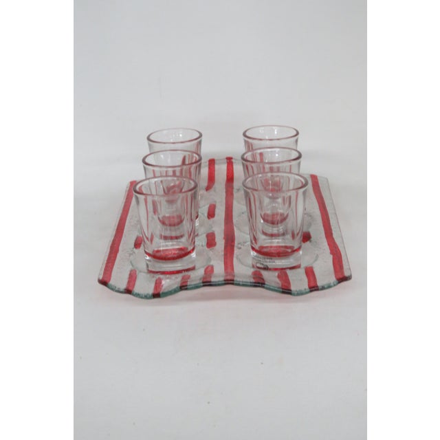 This gorgeous Set of 6 shot glasses and tray are made of glass. This set has a wonderful small silhouette, wavey tray with...