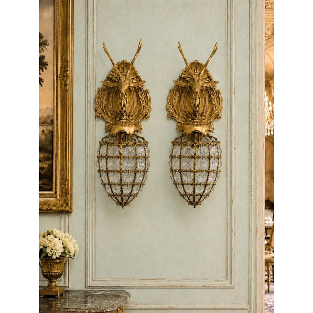 A decorative pair of late 20th-century French Louis XVI–style wall sconces, crafted in bronze with a warm gilt finish and...