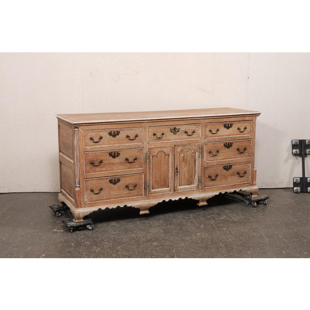 A French carved oak buffet cabinet from the 19th century. This antique console cabinet from France features abundant...