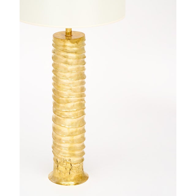 Pair of lamps from Italy made in the Modernist style. Each lamp has a brass cylindrical structure with an emanating wave...