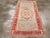 An antique Turkish Oushak accent rug. A bilaterally symmetric oval bouquet medallion with floral garland corners is set on...