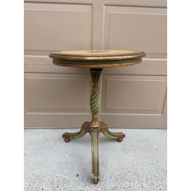An elegant Regency-style flip-top side table in painted walnut, featuring hand-painted gold decoration against a soft...