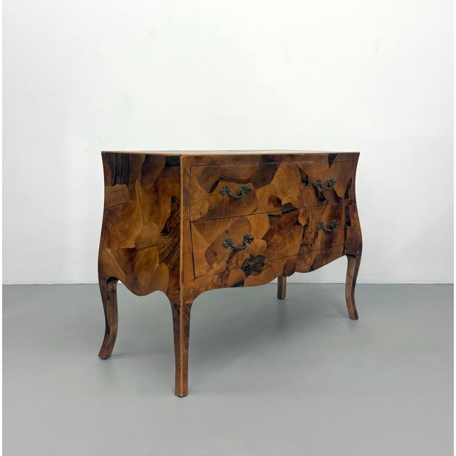 A striking vintage bombe chest showcasing an exceptional patchwork burl wood veneer with rich organic grain and dramatic...