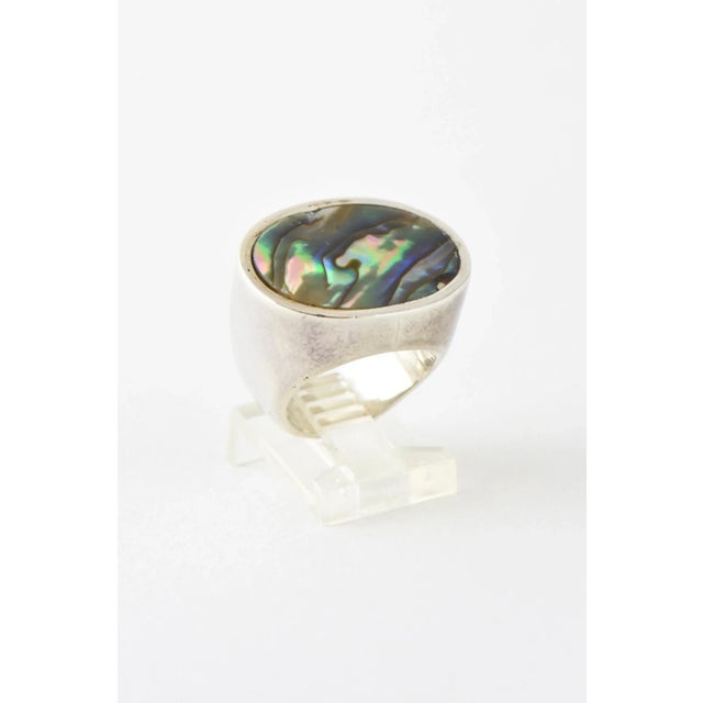 Handmade oval bezel-set abalone shell mounted in a sterling silver ring by Barry Brinker. U.S. size: 5.5. Marked "925"...
