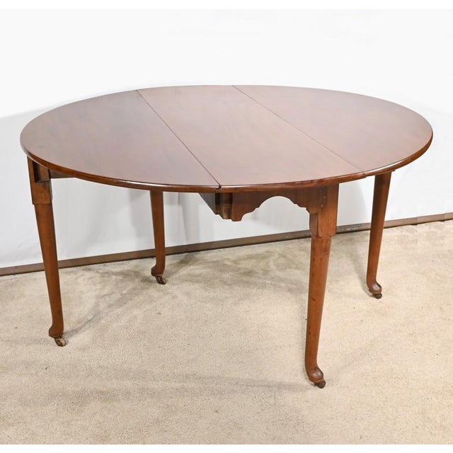 This mahogany table, English workmanship and slightly oval shape, has two flaps supported by two folding legs. In addition...