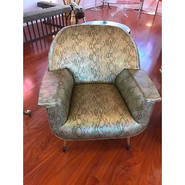 Stunning pair of Italian Mid-Century club chairs upholstered in faux snake skin. Having arched backs and flared arms,...