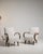 Pair of bentwood-arm lounge chairs in Warm Ivory Boucle. The warm ivory boucle surface highlights curved wood open arms,...