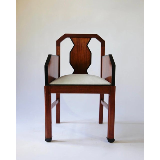 Distinctive Art Deco armchair with armrests, dating from around 1930. The chair features a richly finished wooden frame...