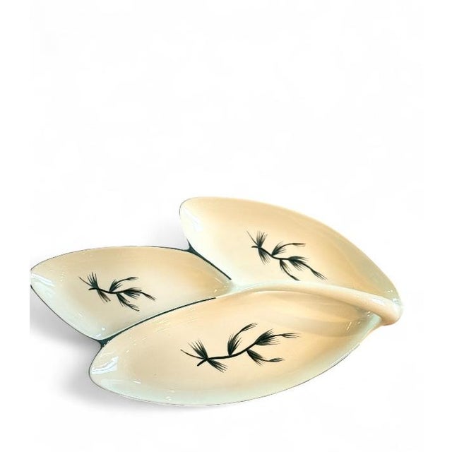 Crafted by Winfield Pottery in the 1950s, this cream-glazed, three-leaf serving tray features hand-painted teal pine...